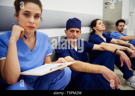 Gruppo di chirurghi stanchi dopo una lunga giornata di lavoro Foto Stock