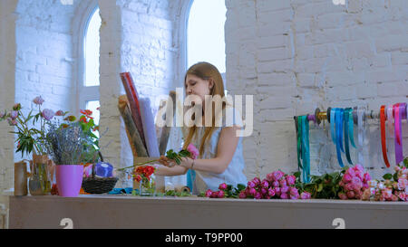 Florist professionista lavora con fiori in studio Foto Stock