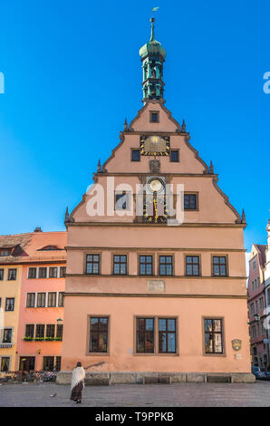 Immagine perfetta del famoso Ratstrinkstube (Assessore's Tavern) a Rothenburg ob der Tauber, Germania. Una donna di fronte alla bella facciata ammira... Foto Stock