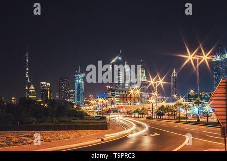 Paesaggio notturno con vedute dei grattacieli e il Burj Khalifa dal lato della strada Foto Stock