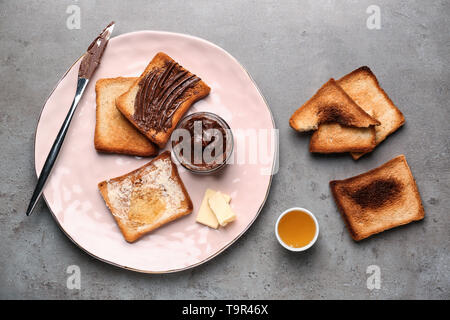Composizione con gustose bruschette, spargimento di cioccolato e miele sul tavolo Foto Stock