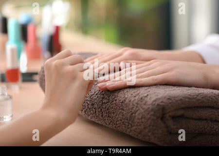 Giovane donna getting bella manicure in salone Foto Stock