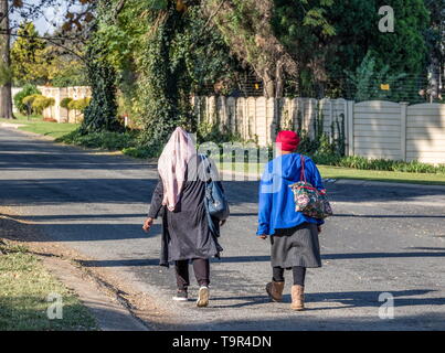 Johannesburg, Sud Africa - non identificato due donne nere a casa a piedi nel pomeriggio dai loro posti di lavoro in città immagine in formato orizzontale Foto Stock