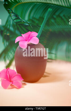 Noce di cocco cocktail con cannucce potabile e fiore tra palm tree foglie Foto Stock