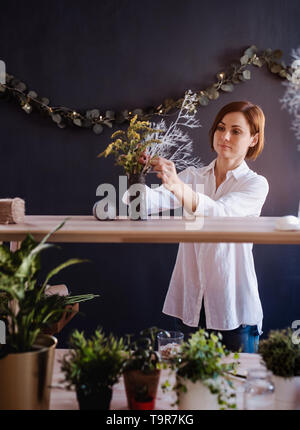 I giovani creativi donna in un negozio di fiori. Un avvio di attività di fiorista. Foto Stock