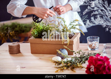 Una sezione mediana della giovane donna creativa in un negozio di fiori. Un avvio di attività di fiorista. Foto Stock