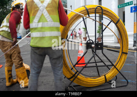 15.04.2018, Singapore, Repubblica di Singapore, in Asia - due lavoratori sono la posa di cavi su una strada nel quartiere centrale degli affari. Foto Stock