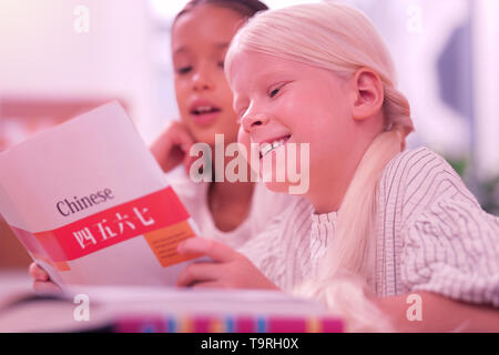 Due ragazze sorridenti imparare il cinese a scuola. Foto Stock
