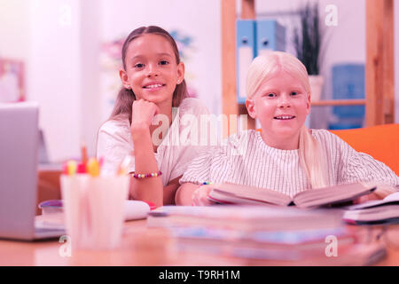 Due bambini felici seduto alla scrivania. Foto Stock