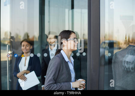 La gente di affari camminando attraverso la porta girevole Foto Stock