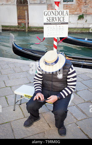 Gondoliere texting sul suo smart phone Foto Stock