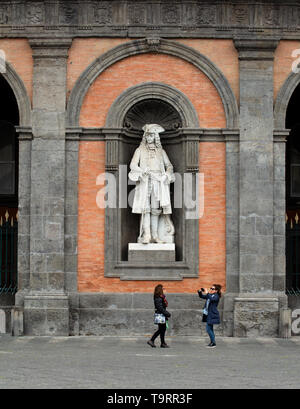 I turisti di scattare una foto davanti alla statua di Carlo III di Spagna sulla facciata del Palazzo Reale di Napoli, Italia Foto Stock