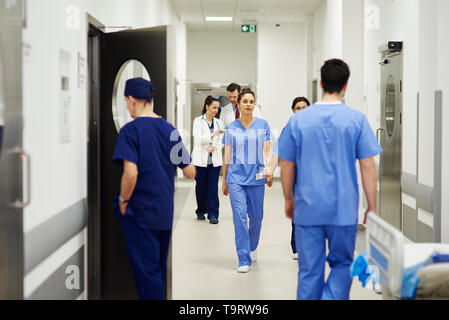 I medici a piedi attraverso il corridoio in ospedale Foto Stock