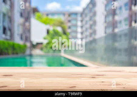 Tavolo in legno top con condominio alloggio blur sullo sfondo per modello per pubblicità Foto Stock