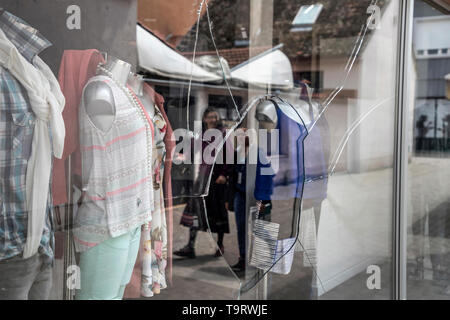 Slavonski Brod, Croazia, 17 Maggio 2019: Downtown in scena con la vetrina della boutique di vandalismo e di riflessione delle persone che camminano per la strada Foto Stock