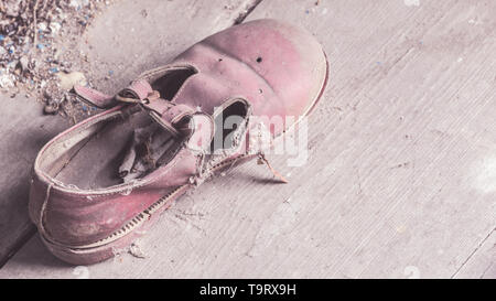 Abbandonata piccola scarpa per bambini coperta di polvere in una casa crollata in Bielorussia, zona di esclusione di Chernobyl Foto Stock