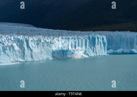 Una sezione del Ghiacciaio Perito Moreno vitelli di gocciolamento di tonnellate di ghiaccio del ghiacciaio nel Lago Argentino nel parco nazionale Los Glaciares vicino a El Calafate, Argent Foto Stock