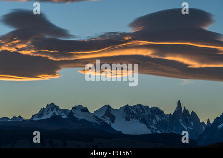 Colorato nubi lenticolari al tramonto del Adela massiccio e il Cerro Torre. Parco nazionale Los Glaciares vicino a El Chalten, Argentina. Un patrimonio mondiale H Foto Stock