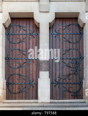 Dettaglio di una vecchia porta di legno con letti in ferro battuto con decorazioni Foto Stock