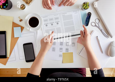 Vista aerea del giovane designer UX la pianificazione della struttura di un sito web. Wireframing stadio di un web design project Foto Stock