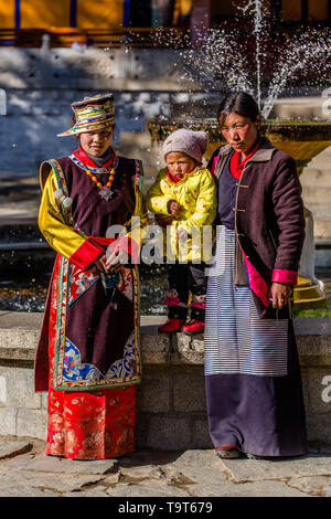 Una donna tibetana in abito festivo a Lhasa, in Tibet, insieme con un Khamba donna tibetana del Kham regione del Tibet orientale. Foto Stock