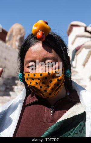 Un Khamba donna tibetana del Kham regione del Tibet orientale con i suoi capelli in stile tradizionale molte piccole trecce e un headddress di porcellana e re Foto Stock