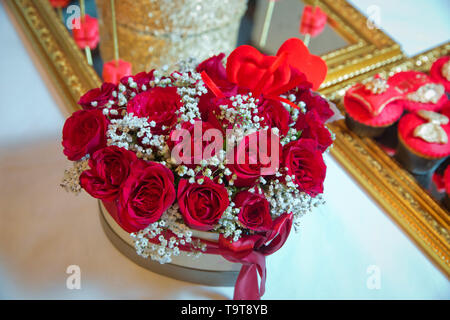 A forma di cuore ad mazzo di bellissimi fiori rosa in confezione regalo . Fatte a mano rosa e rosso bouquet Rose In amore a forma di cuore per San Valentino in close-up . una scatola ho Foto Stock