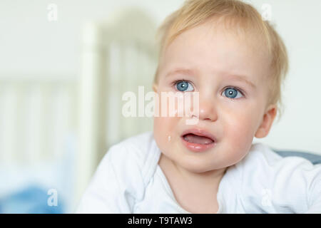Carino bionda caucasica toddler boy ritratto a piangere a casa durante il hysterics. Bambino sensazione triste. Piccolo pensieroso baby dopo quarell. Foto Stock