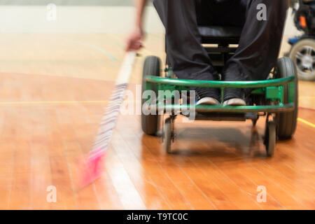 Disabilitato l'uomo su una sedia elettrica sport, powerchair hockey. IWAS - sedia a rotelle internazionale e amputato federazione sportiva Foto Stock