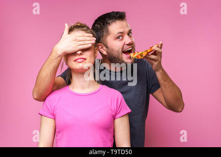 Immagine dell uomo con la pizza in mani di chiudere gli occhi di donna Foto Stock