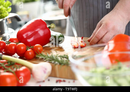 Lo Chef mani il taglio di Red Hot Chili Pepper metà Foto Stock