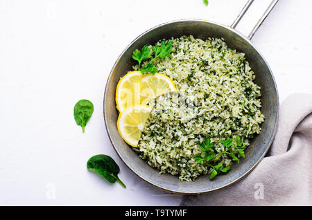 Gli spinaci il riso in una padella su sfondo bianco, Riso Verde, sano cibo vegetariano Foto Stock