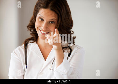 Medico donna puntando verso la telecamera. Foto Stock