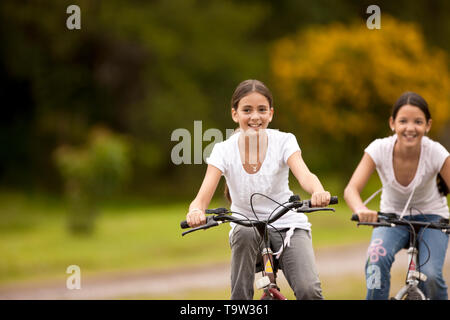 Due ragazze godendo la bicicletta sulla strada di ghiaia. Foto Stock