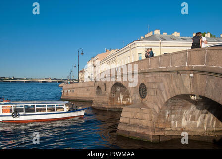 SAINT-Petersburg, Russia - 18 Maggio 2019: Persone con un cane sul ponte Pracheshny guarda l'escursione in barca sul fiume Neva Foto Stock