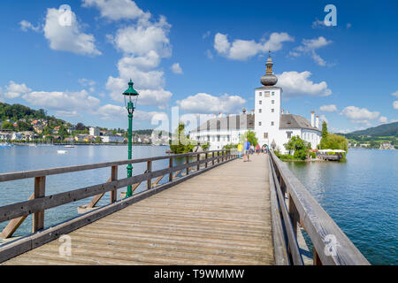 Bellissima vista del famoso Schloss Ort con ponte in legno sul Lago Traunsee in una giornata di sole con cielo blu e nuvole in estate, Gmunden, Salzkammergut reg Foto Stock