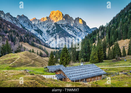 Bellissimo paesaggio delle Alpi con un tradizionale chalet di montagna e incandescente vertici nella bella luce della sera, Nationalpark Berchtesgadener Land, B Foto Stock