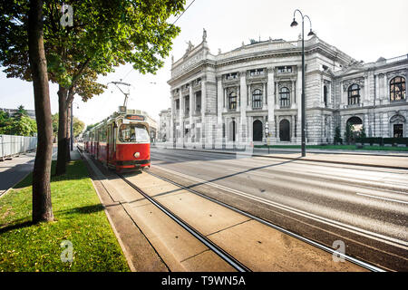 Bellissima vista del celebre Wiener Ringstrasse con Burgtheater storico (Imperial Court Theatre) e tradizionale rosso tram elettrico al tramonto in Vienna Foto Stock
