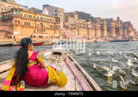 Donna indiana in turistica tradizionale sari godere di escursione in barca a Varanasi con vista di uccelli migratori sul fiume Gange Foto Stock