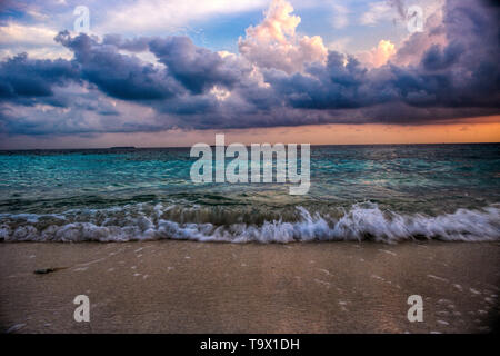 Questa unica immagine mostra il gigantesco tramonto alle Maldive. Si può facilmente vedere come il cielo raffiche e tutto diventa arancione Foto Stock