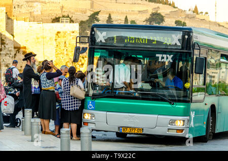Gerusalemme, Israele- Agosto 17, 2016: un gruppo di ebrei ortodossi in attesa di ottenere su un trasporto pubblico bus alla porta del Letame fermata autobus nella città vecchia di Gerusalemme Foto Stock