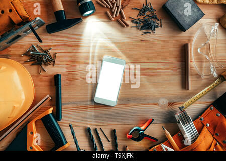 Smartphone mock up su Falegnameria Officina di falegnameria scrivania, vista dall'alto Foto Stock