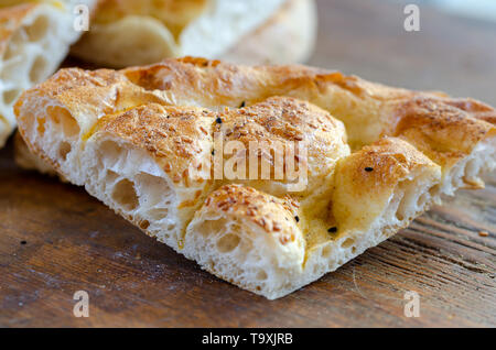 Fetta di Ramadan Pita (Ramazan Pidesi) tradizionale pane turco per il mese sacro del Ramadan su sfondo di legno. Concetto di Ramadan. Foto Stock