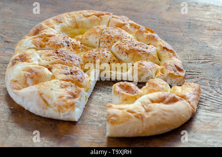 Fette di Ramadan Pita (Ramazan Pidesi) tradizionale pane turco per il mese sacro del Ramadan su sfondo di legno. Concetto di Ramadan. Foto Stock