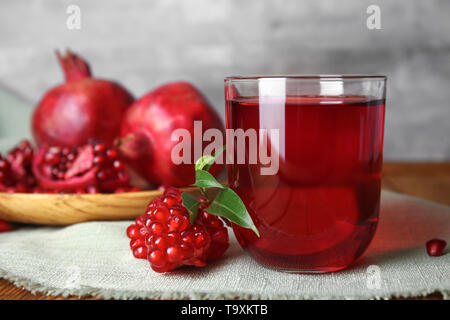 Bicchiere di gustoso succo di melograno su tavola Foto Stock