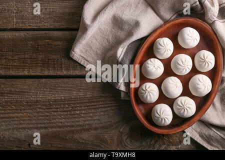 Piastra con raw gnocchi Cinesi sul tavolo di legno Foto Stock