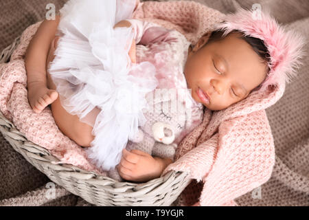 Carino afro-americano di baby dormire nel cesto di vimini Foto Stock