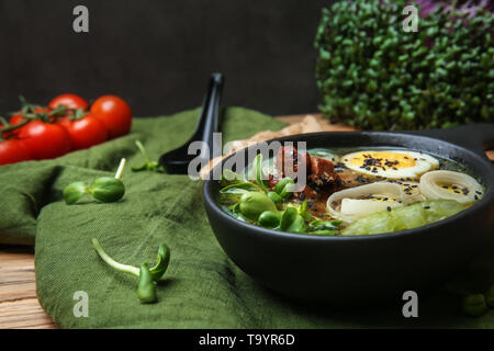 Gustosa zuppa cinese nella ciotola sul tavolo Foto Stock