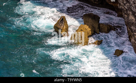 onde che entrano in un'insenatura e si schiantano contro le rocce Foto Stock