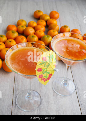 Spremuta di mandarino succo in vetro su rustico sfondo di legno Foto Stock